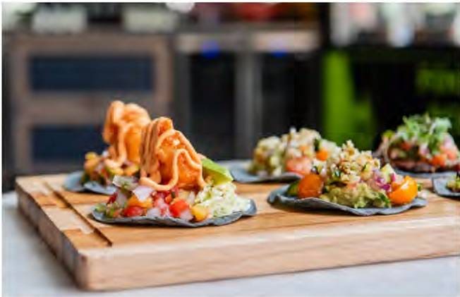 A wooden table topped with plates of food.