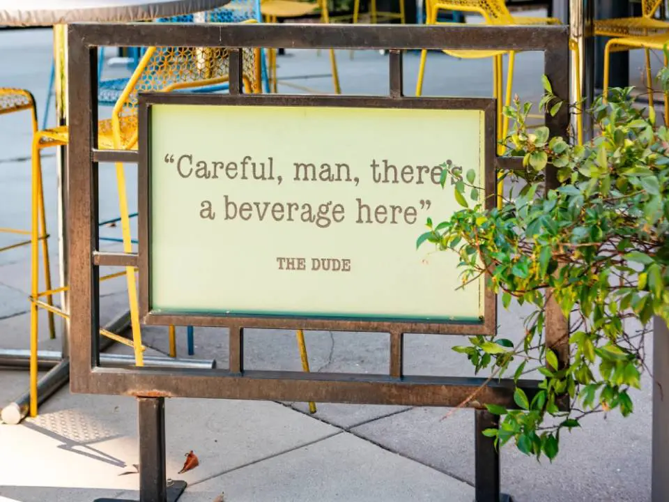 A sign that says careful, man, there 's a beverage here.